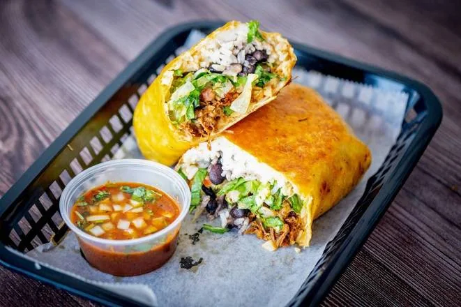 CocoRay's birria burrito served in a basket with consommé for dipping