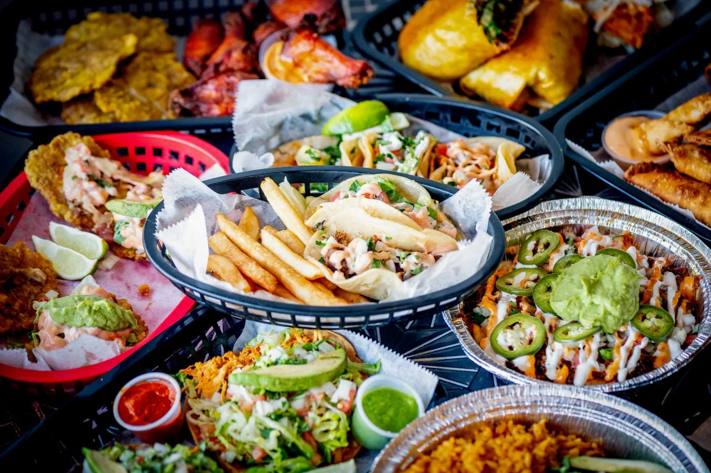 A colorful spread of CocoRay's tacos, loaded fries, plantains, and Puerto Rican favorites